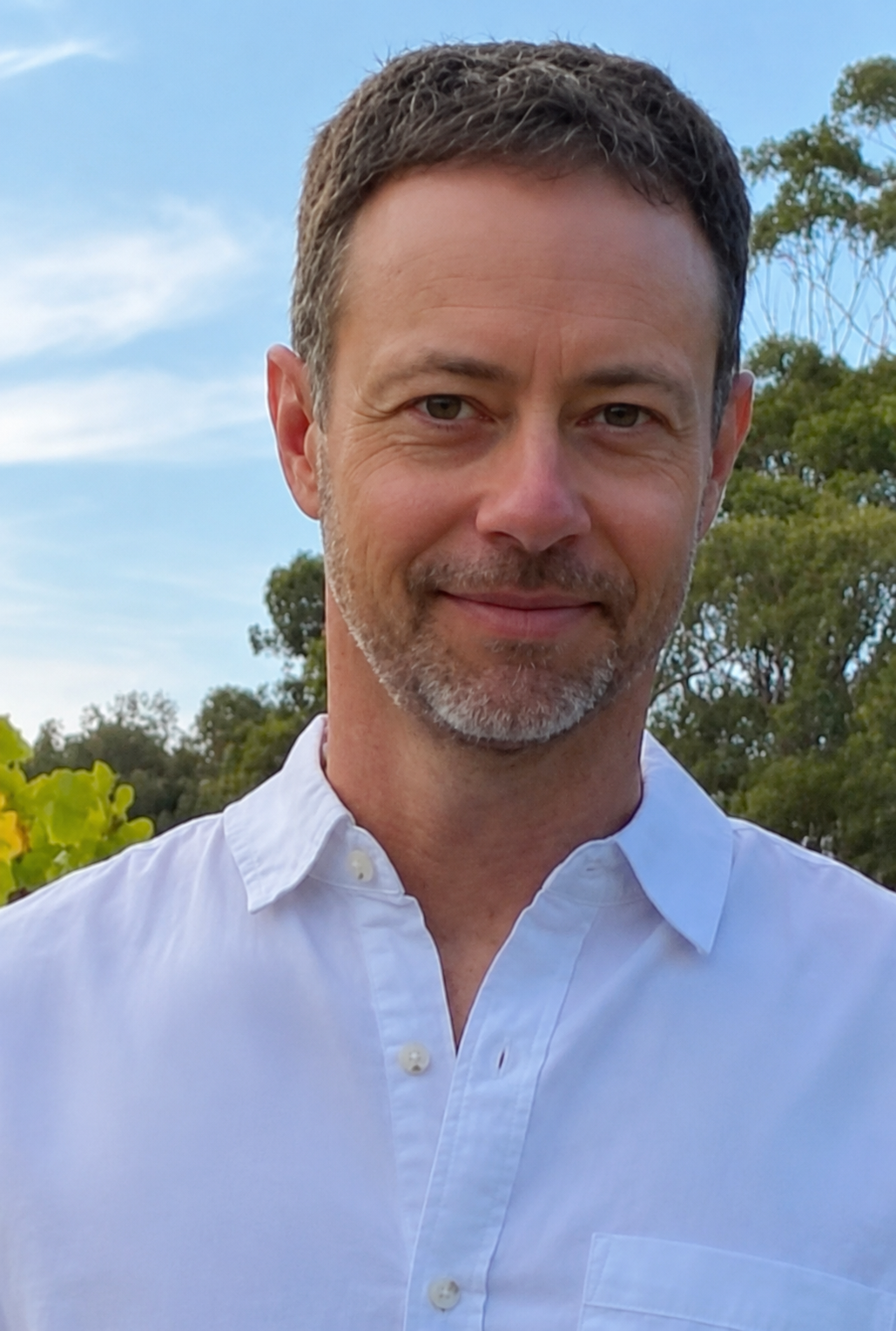 Man wearing a white shirt with a blurred natural background